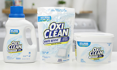 OxiClean White Revive liquid, laundry paks and powder lined up on a counter.