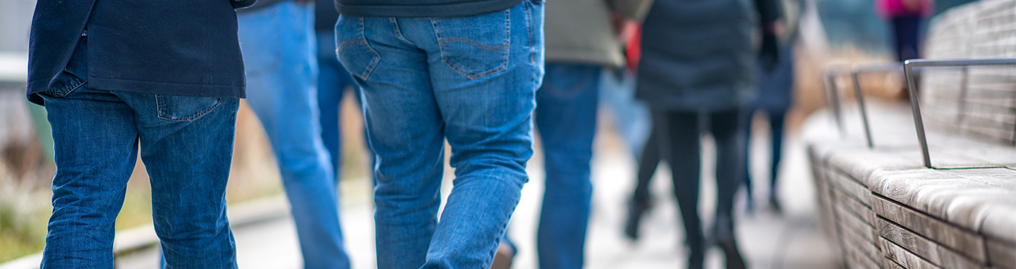 People in jeans walking along the High Line in Manhattan, New York City.