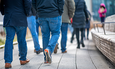 People in jeans walking along the High Line in Manhattan, New York City.